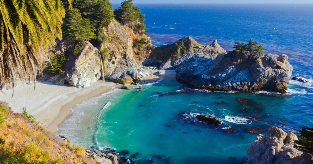 McWay Falls is a picturesque waterfall along California's Big Sur coast, dropping onto a sandy cove surrounded by rugged cliffs and lush greenery.