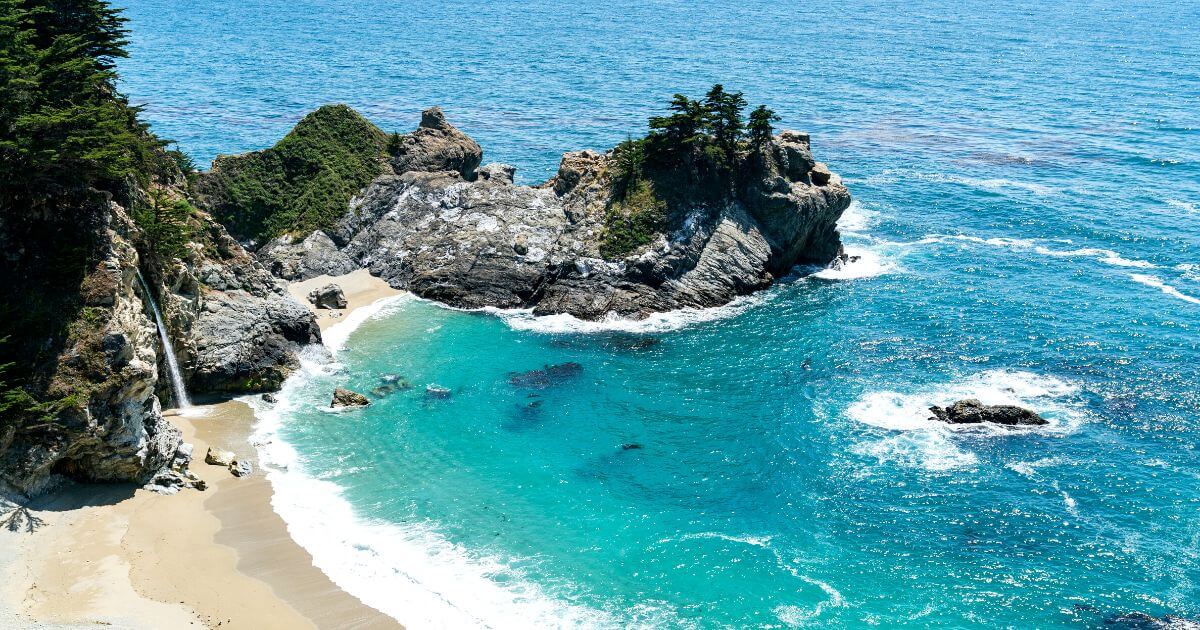 McWay Falls, one of the best California Nature Spots, falling directly onto beautiful McWay Beach on a sunny day