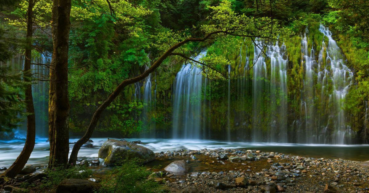 Water flowing through mossy rock into the Sacramento River at Mossbrae Falls, one of the best nature spots in California