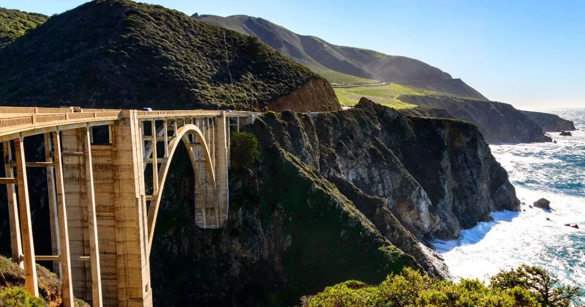 Impressive arched Bixby Bridge spanning a deep chasm with rugged cliffs, overlooking the ocean in Big Sur