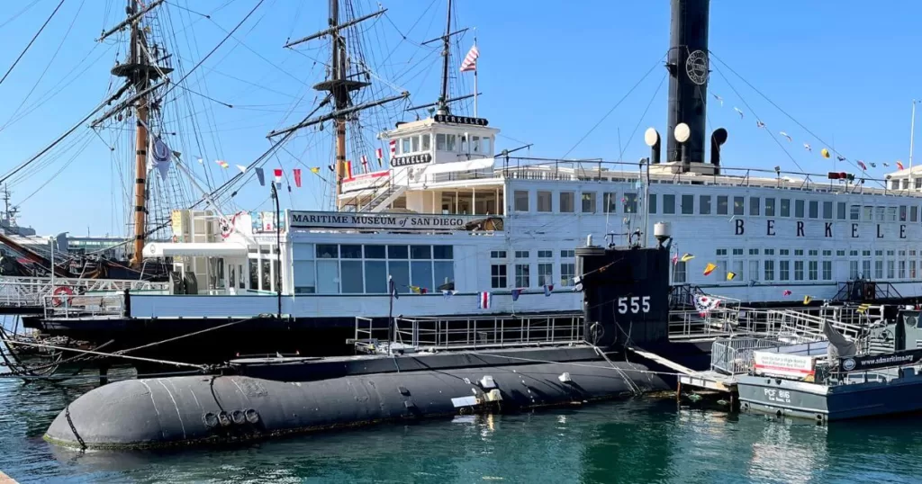 Maritime Museum of San Diego with historic ships, including a submarine and the ferryboat Berkeley, docked along the sunny waterfront.