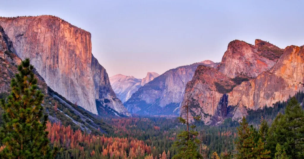 A breathtaking view from Tunnel View overlook in Yosemite National Park, showcasing the iconic vistas that make it one of the best national parks on the US West Coast, with El Capitan and Bridalveil Fall standing prominently against the captivating backdrop of the High Sierras.