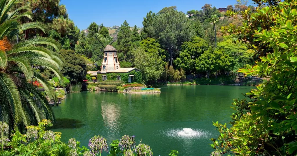 Serene Lake Shrine in Los Angeles, featuring lush gardens, a tranquil pond, and a picturesque windmill, providing a peaceful retreat within the bustling city.