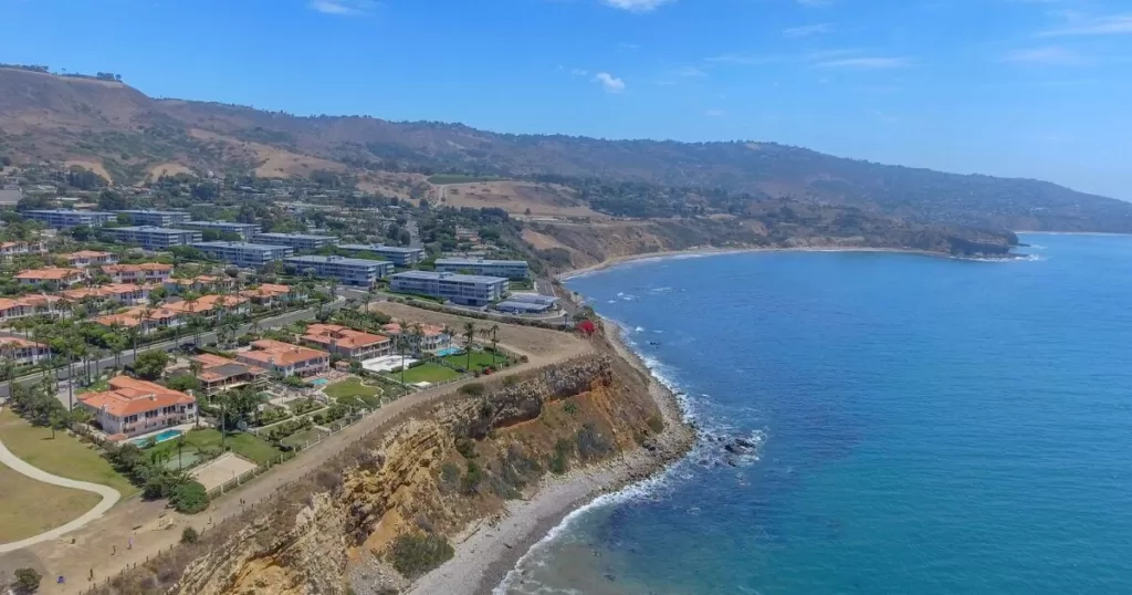 Aerial view of the picturesque Palos Verdes Peninsula coastline, with its mix of luxury homes and natural landscapes, overlooking the azure Pacific Ocean.