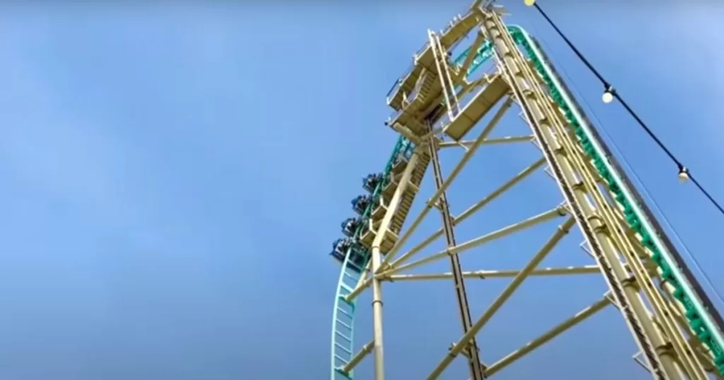 Thrill-seekers ascend a towering roller coaster at Knott's Berry Farm, a highlight among things to do in California with kids, against a clear blue sky.