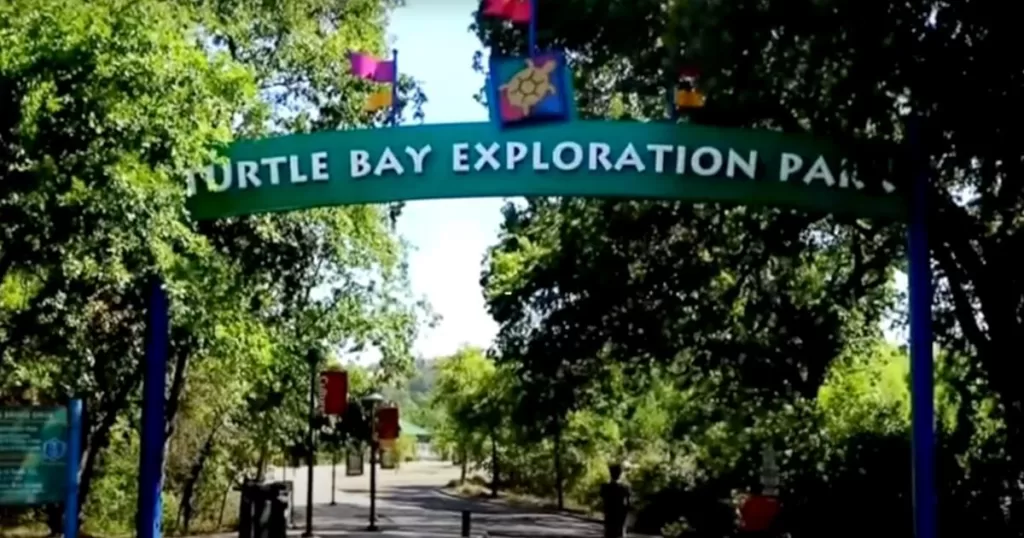 Entrance sign of Turtle Bay Exploration Park adorned with colorful flags, inviting visitors to one of the engaging things to do in California with kids.