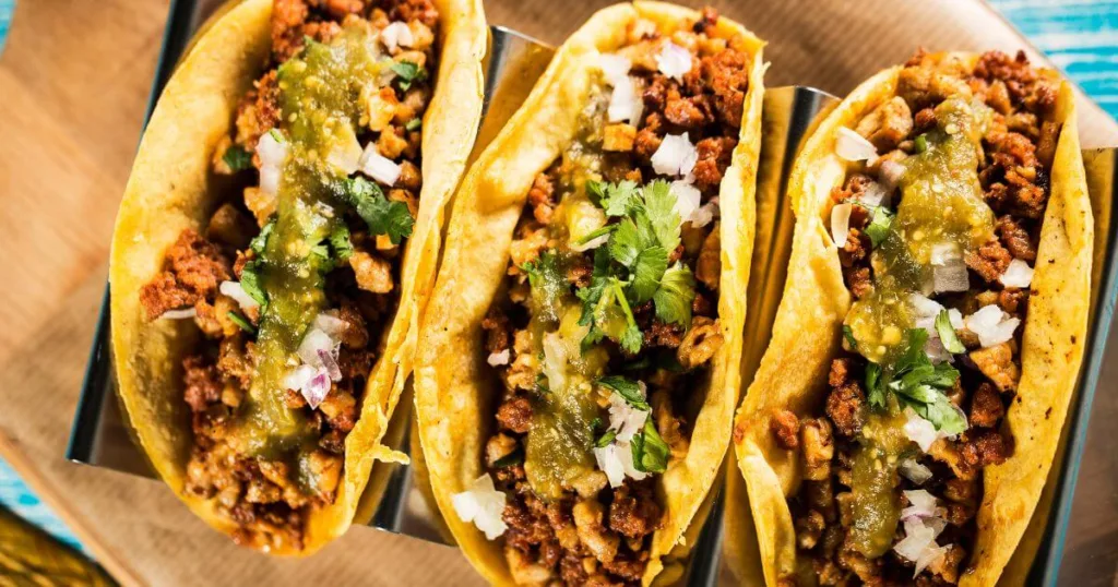 A tantalizing selection of tacos served on a food tour in Avalon, one of the many things to do on Catalina Island, featuring seasoned meat, fresh cilantro, onions, and tangy salsa.